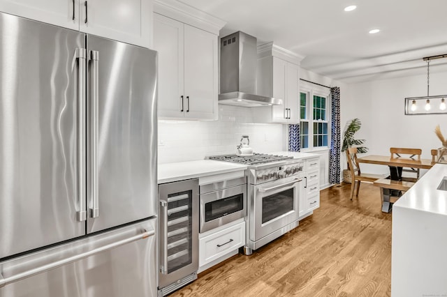 6 Buckboard Ln, Fairfield, CT 06824 - kitchen featuring premium appliances, wall chimney range hood, beverage cooler, light countertops, and recessed lighting