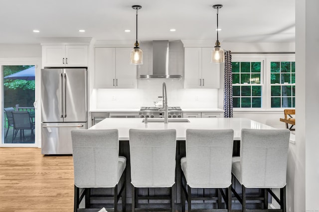 6 Buckboard Ln, Fairfield, CT 06824 - kitchen with high end fridge, wall chimney exhaust hood, a breakfast bar, light countertops, and recessed lighting