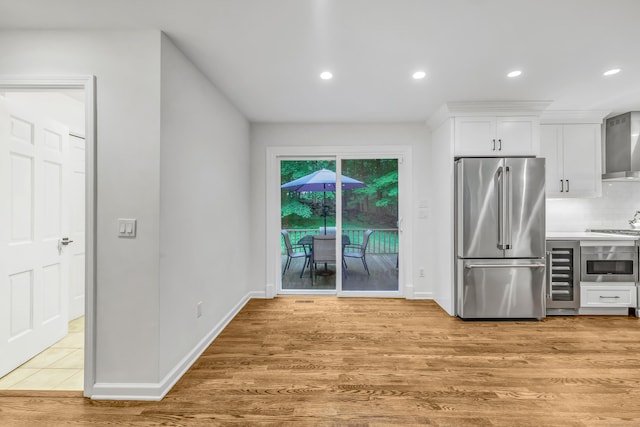 6 Buckboard Ln, Fairfield, CT 06824 - kitchen featuring stainless steel appliances, beverage cooler, wall chimney exhaust hood, white cabinets, and backsplash