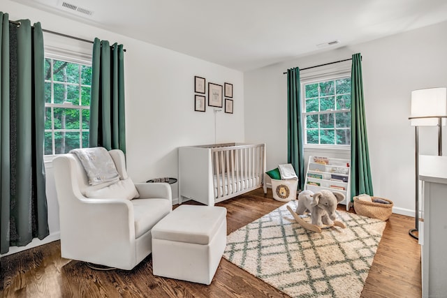 6 Buckboard Ln, Fairfield, CT 06824 - bedroom featuring multiple windows, a nursery area, and wood finished floors