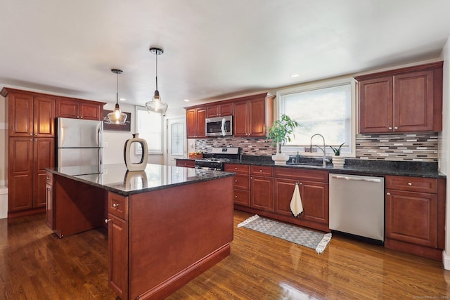 98 Herald Ave, Bridgeport, CT 06606 - kitchen with appliances with stainless steel finishes, a sink, dark wood finished floors, a kitchen island, and backsplash