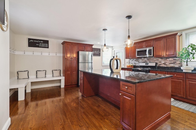 98 Herald Ave, Bridgeport, CT 06606 - kitchen with appliances with stainless steel finishes, a center island, dark wood finished floors, backsplash, and decorative light fixtures