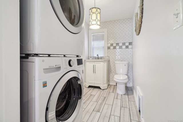 98 Herald Ave, Bridgeport, CT 06606 - laundry area with stacked washer / dryer and tile walls
