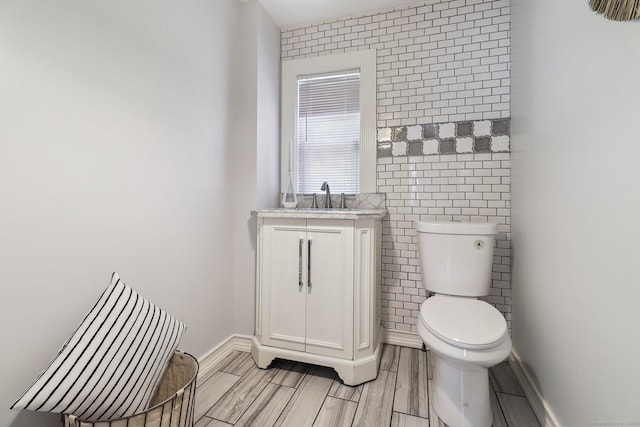 98 Herald Ave, Bridgeport, CT 06606 - half bathroom featuring toilet, tile walls, vanity, and baseboards