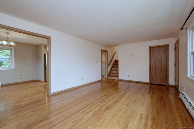 15 Edgemere Rd, Hamden, CT 06517 - spare room with baseboard heating, light wood finished floors, stairway, and a chandelier