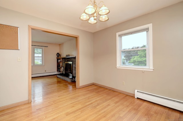 15 Edgemere Rd, Hamden, CT 06517 - unfurnished living room with a baseboard heating unit, a chandelier, light wood finished floors, and a fireplace