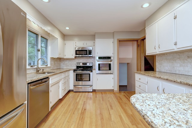 15 Edgemere Rd, Hamden, CT 06517 - kitchen with appliances with stainless steel finishes, white cabinets, light wood finished floors, backsplash, and recessed lighting