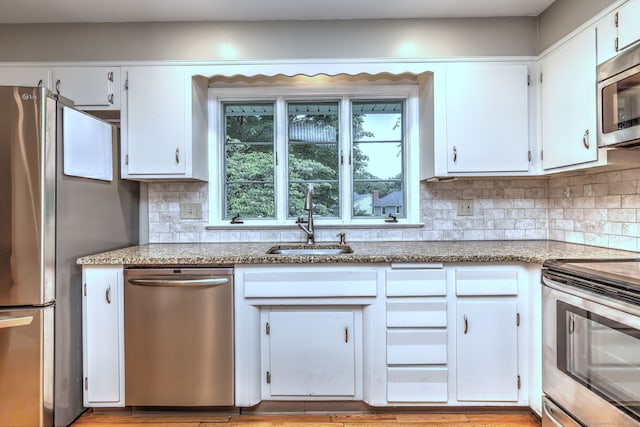 15 Edgemere Rd, Hamden, CT 06517 - kitchen featuring stainless steel appliances, white cabinetry, decorative backsplash, and light stone counters