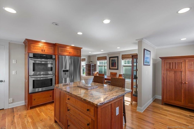 10 Point Beach Dr, Milford, CT 06460 - kitchen featuring stainless steel appliances, crown molding, a kitchen island, brown cabinets, and light wood-type flooring