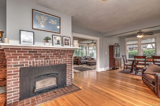 17 Norris St, Hamden, CT 06517 - living room with ceiling fan, hardwood / wood-style floors, a fireplace, a textured ceiling, and healthy amount of natural light