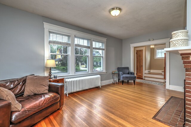 17 Norris St, Hamden, CT 06517 - living area featuring radiator heating unit, hardwood / wood-style floors, stairs, and a textured ceiling