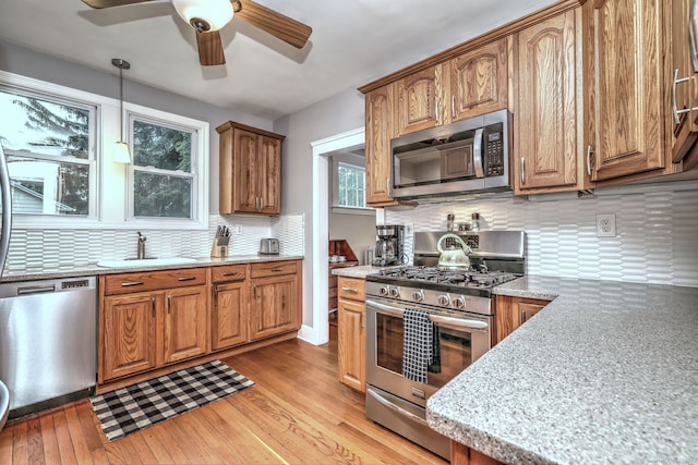 17 Norris St, Hamden, CT 06517 - kitchen with stainless steel appliances, light wood-style floors, ceiling fan, decorative backsplash, and brown cabinetry