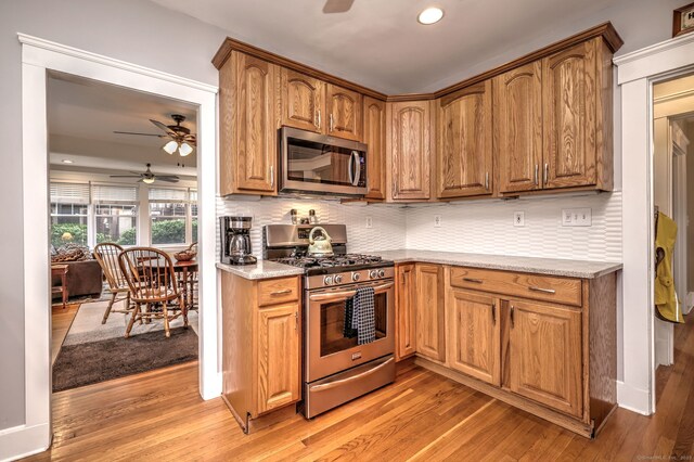 17 Norris St, Hamden, CT 06517 - kitchen featuring stainless steel appliances, ceiling fan, light wood finished floors, decorative backsplash, and recessed lighting