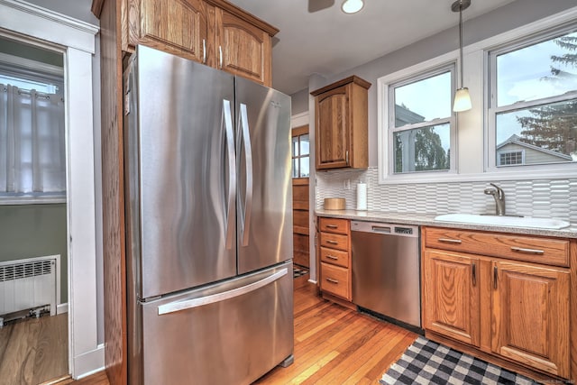 17 Norris St, Hamden, CT 06517 - kitchen with stainless steel appliances, light wood-style flooring, brown cabinetry, and radiator heating unit