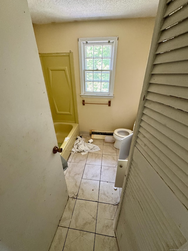 38 Makara St, Plymouth, CT 06786 - full bath with a baseboard radiator, a bath, toilet, tile patterned floors, and a textured ceiling