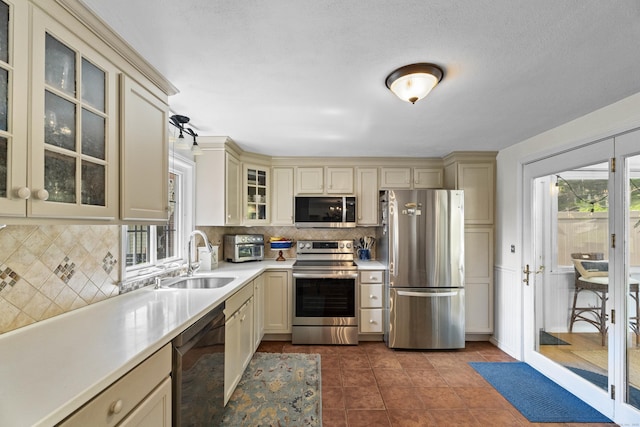 96 Long Hill Ter, New Haven, CT 06515 - kitchen with stainless steel appliances, cream cabinets, a sink, light countertops, and plenty of natural light