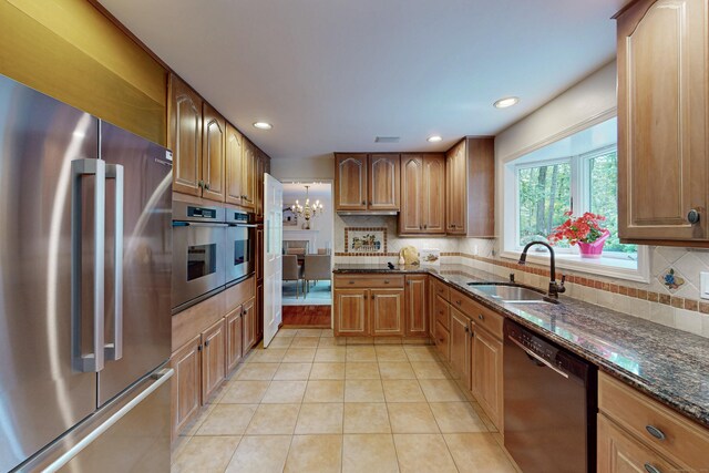 305 Thayer Pond Rd, Wilton, CT 06897 - kitchen with appliances with stainless steel finishes, a sink, dark stone countertops, light tile patterned floors, and a chandelier