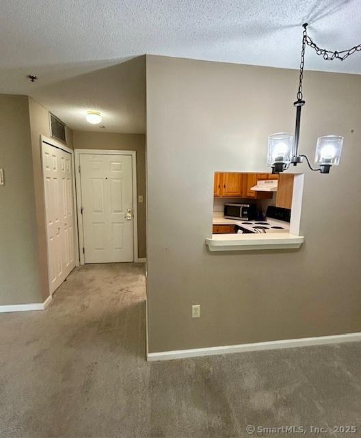 625 Palisado Ave Apt 206, Windsor, CT 06095 - corridor featuring carpet flooring, baseboards, a chandelier, and a textured ceiling