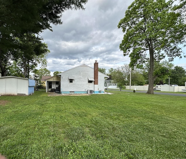 130 Judd Ave, New Britain, CT 06051 - back of property with a chimney, a lawn, and cooling unit