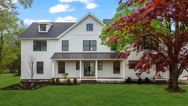 52 Garibaldi Ln, New Canaan, CT 06840 - modern farmhouse featuring board and batten siding, covered porch, a standing seam roof, a front lawn, and metal roof