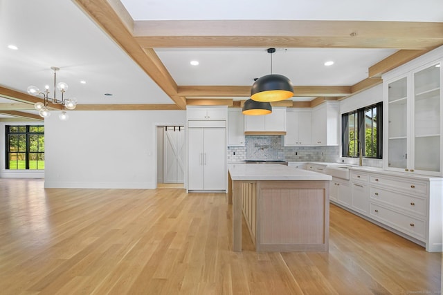 52 Garibaldi Ln, New Canaan, CT 06840 - kitchen with healthy amount of natural light, beamed ceiling, a sink, tasteful backsplash, and a chandelier