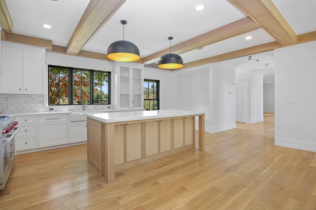 52 Garibaldi Ln, New Canaan, CT 06840 - kitchen with beam ceiling, a kitchen island, light wood-style floors, light countertops, and range with two ovens