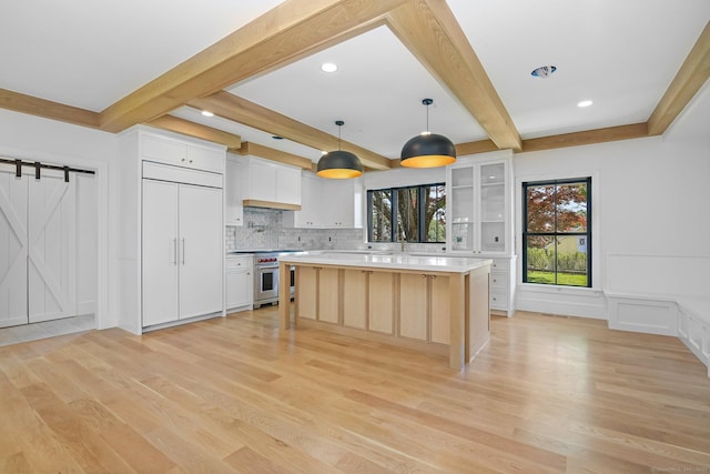 52 Garibaldi Ln, New Canaan, CT 06840 - kitchen featuring premium appliances, light wood-style flooring, beamed ceiling, light countertops, and a decorative wall
