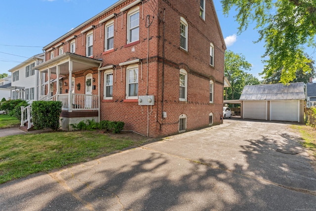 28 Chestnut St, Windsor Locks, CT 06096 - view of home's exterior with brick siding, a garage, an outbuilding, covered porch, and a yard