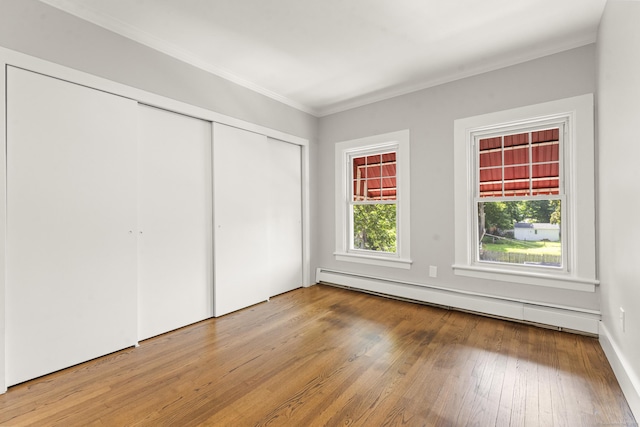 28 Chestnut St, Windsor Locks, CT 06096 - unfurnished bedroom featuring baseboard heating, hardwood / wood-style floors, crown molding, and a closet