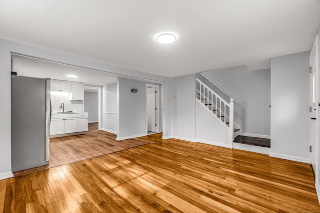 226 Quinn St, Naugatuck, CT 06770 - unfurnished living room with a sink, light wood-style flooring, stairway, and baseboards