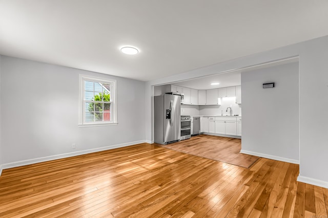 226 Quinn St, Naugatuck, CT 06770 - unfurnished living room with a sink, light wood-type flooring, and baseboards