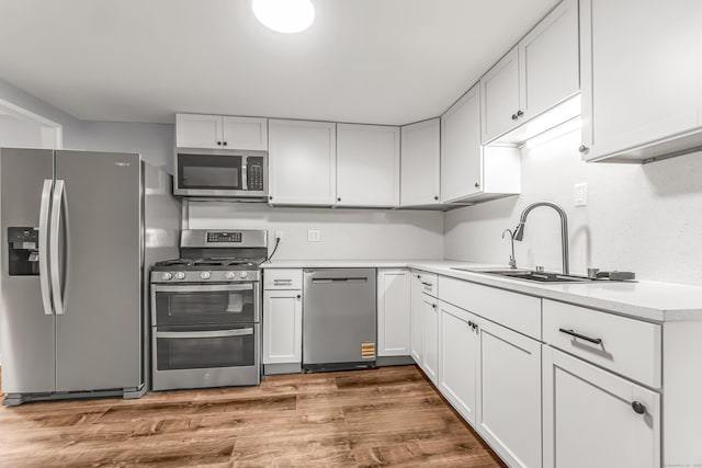 226 Quinn St, Naugatuck, CT 06770 - kitchen featuring stainless steel appliances, a sink, dark wood finished floors, light countertops, and white cabinetry