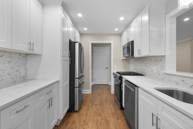 513 Opa Ln Unit B, Stratford, CT 06614 - kitchen featuring stainless steel appliances, recessed lighting, white cabinetry, light wood-style flooring, and backsplash