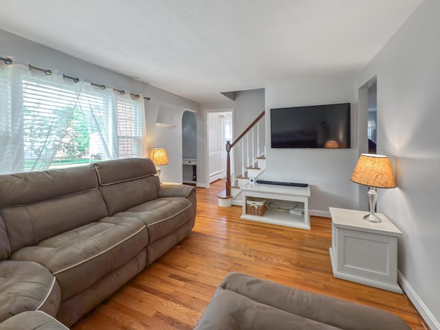 43 Superior Ave, Newington, CT 06111 - living area with stairway, light wood-style flooring, baseboards, and arched walkways