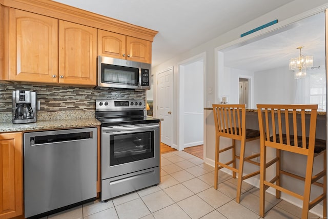 43 Superior Ave, Newington, CT 06111 - kitchen featuring stainless steel appliances, tasteful backsplash, a chandelier, light tile patterned flooring, and light stone countertops