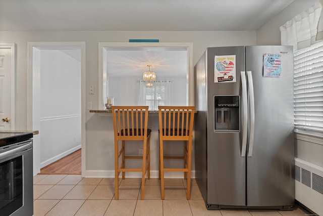 43 Superior Ave, Newington, CT 06111 - kitchen with appliances with stainless steel finishes, radiator heating unit, a chandelier, light tile patterned floors, and baseboards