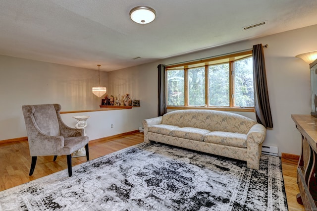50 Sea Hill Rd, North Branford, CT 06471 - living area with light wood-type flooring, baseboards, and a baseboard heating unit