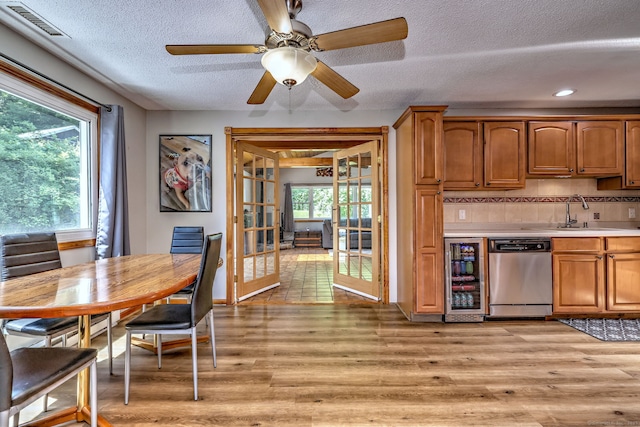 50 Sea Hill Rd, North Branford, CT 06471 - kitchen featuring stainless steel dishwasher, a sink, beverage cooler, light countertops, and a textured ceiling