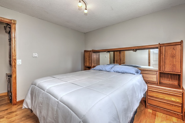 50 Sea Hill Rd, North Branford, CT 06471 - bedroom with light wood finished floors, a textured ceiling, and baseboards