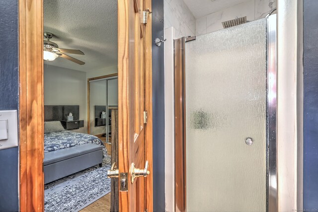 50 Sea Hill Rd, North Branford, CT 06471 - ensuite bathroom with a stall shower, a ceiling fan, wood finished floors, and a textured ceiling