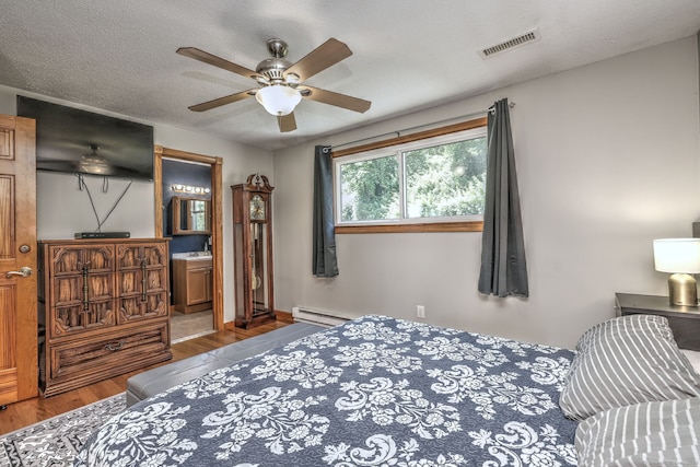 50 Sea Hill Rd, North Branford, CT 06471 - bedroom featuring a baseboard heating unit, wood finished floors, ceiling fan, and connected bathroom