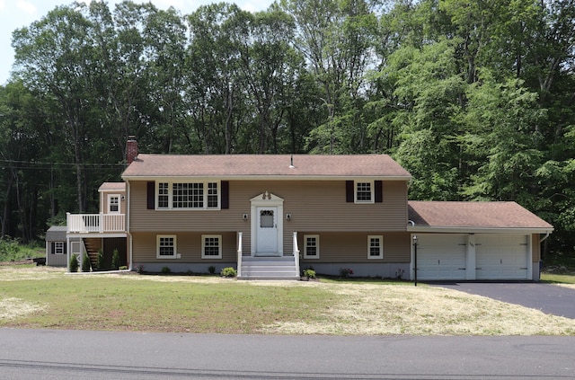 197 New Rd, Tolland, CT 06084 - raised ranch featuring an attached garage, driveway, a front yard, and a chimney