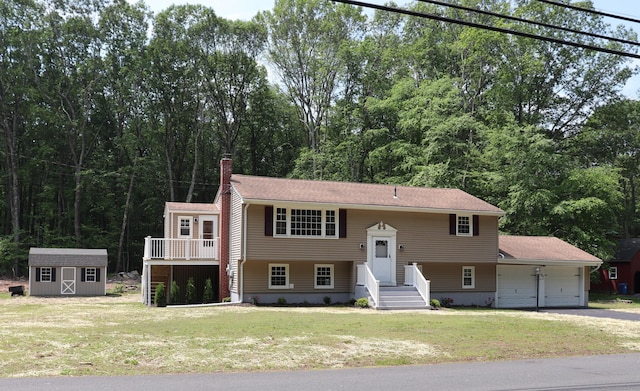 197 New Rd, Tolland, CT 06084 - raised ranch featuring a garage, a chimney, a front lawn, and driveway