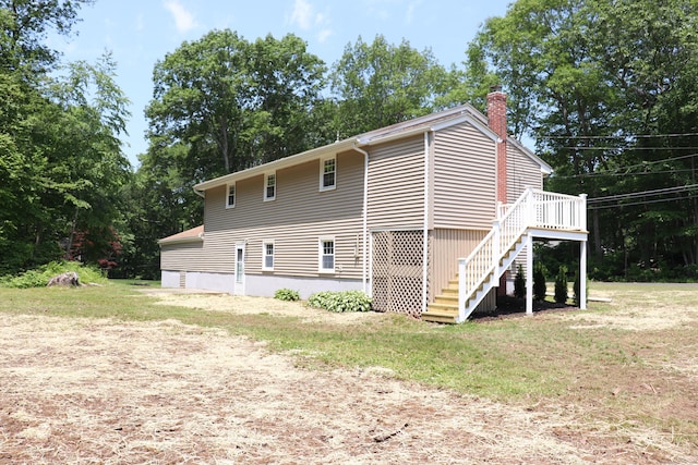 197 New Rd, Tolland, CT 06084 - view of side of home with a chimney, stairway, a wooden deck, and view of scattered trees