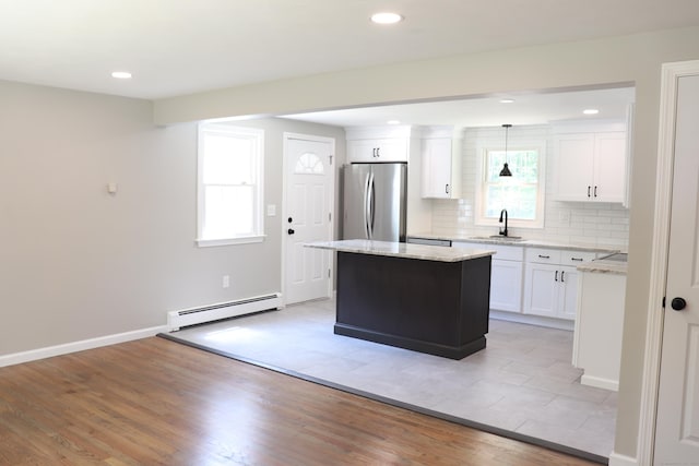 197 New Rd, Tolland, CT 06084 - kitchen featuring freestanding refrigerator, baseboard heating, white cabinetry, a sink, and a kitchen island