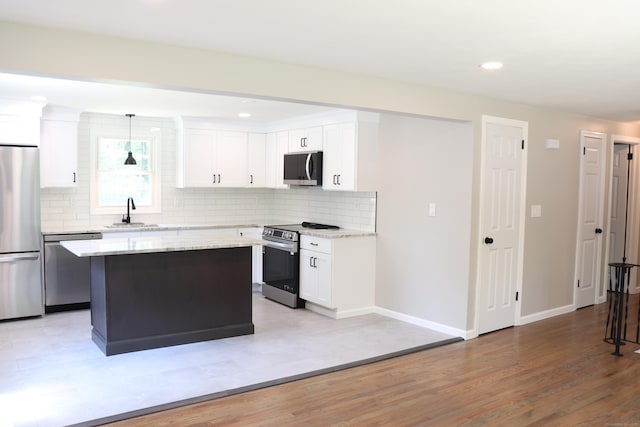197 New Rd, Tolland, CT 06084 - kitchen with appliances with stainless steel finishes, backsplash, baseboards, a sink, and white cabinetry