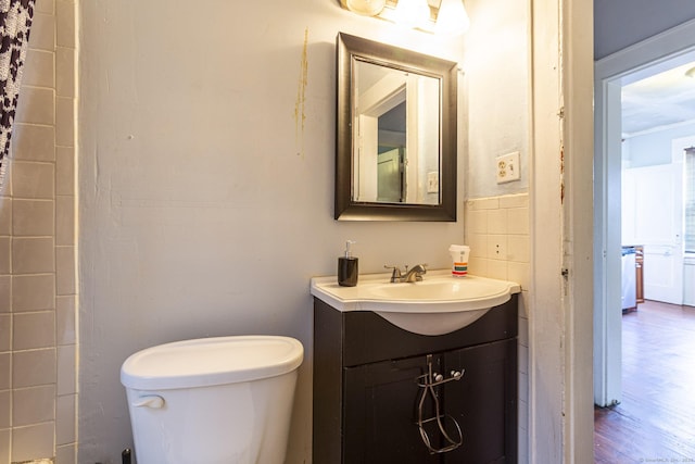 3800 Main St, Stratford, CT 06614 - bathroom with toilet, vanity, wood finished floors, and tile walls