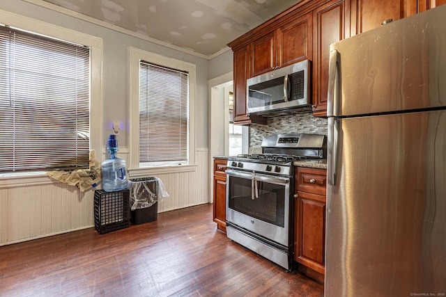 3800 Main St, Stratford, CT 06614 - kitchen featuring stainless steel appliances, dark wood-style flooring, crown molding, decorative backsplash, and dark stone counters