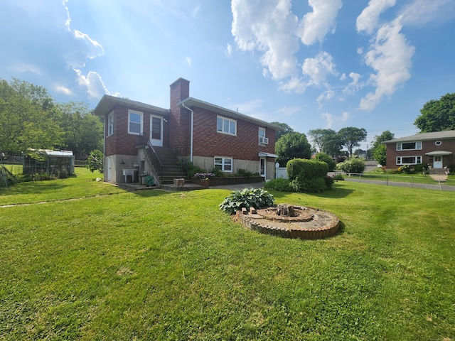 82 Hotchkiss St, Waterbury, CT 06704 - rear view of house with a fire pit, a chimney, brick siding, and stairway