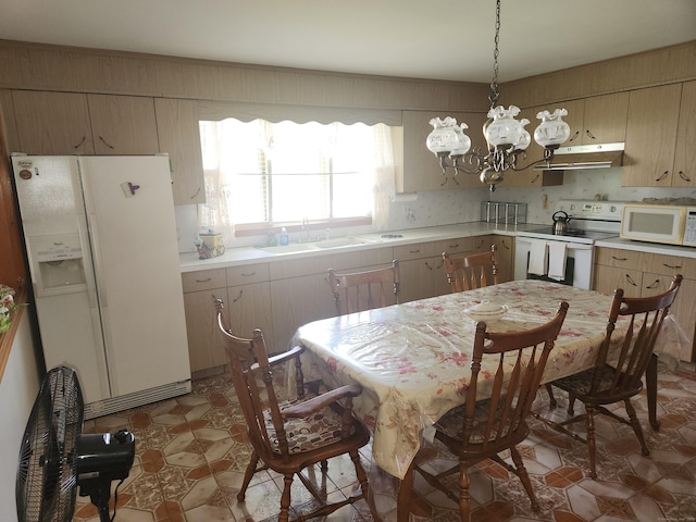 82 Hotchkiss St, Waterbury, CT 06704 - kitchen with white appliances, under cabinet range hood, light countertops, a chandelier, and pendant lighting